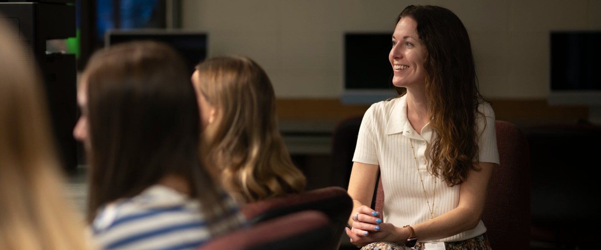 Alumna Olivia Brandt sitting behind her students